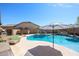 A backyard pool with a slide, waterfall feature, and a jacuzzi offers a fun and relaxing retreat in this private outdoor space at 16511 W Cortez St, Surprise, AZ 85388