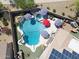 Aerial view of a sparkling backyard pool with a slide, diving board, jacuzzi, and solar panels on roof at 16511 W Cortez St, Surprise, AZ 85388