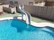 Large pool slide with blue water and artificial turf, creating a fun and inviting backyard space at 16511 W Cortez St, Surprise, AZ 85388