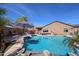 Private backyard pool with a waterfall feature, jacuzzi and covered patio, is surrounded by tropical landscaping for a relaxing oasis at 16511 W Cortez St, Surprise, AZ 85388