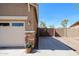 An outdoor space featuring garage access with stone accents and a privacy gate at 16511 W Cortez St, Surprise, AZ 85388