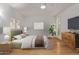 Comfortable bedroom with a ceiling fan, light walls, and a wooden floor at 18211 N Conestoga Dr, Sun City, AZ 85373