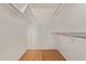 Walk-in closet featuring built-in shelving and hardwood flooring at 18211 N Conestoga Dr, Sun City, AZ 85373