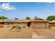 Single-story home featuring a desert rock yard, covered porch, and a two-car garage at 18211 N Conestoga Dr, Sun City, AZ 85373