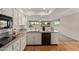 Well-lit kitchen featuring white cabinets and stainless steel appliances at 18211 N Conestoga Dr, Sun City, AZ 85373