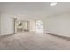 A spacious living room with neutral carpet and white walls with access to outdoor living at 18211 N Conestoga Dr, Sun City, AZ 85373
