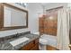 Cozy bathroom with brown granite counters, mirror, shower with curtain, and toilet at 19412 N 77Th Ave, Glendale, AZ 85308
