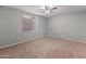 Bright bedroom with plush carpeting, a ceiling fan for comfort, and a sunlit window at 19412 N 77Th Ave, Glendale, AZ 85308
