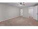 Bedroom with plush carpeting, ceiling fan, and an open doorway leading to another room at 19412 N 77Th Ave, Glendale, AZ 85308