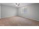 Cozy bedroom with plush carpeting, a ceiling fan for comfort, and a sunlit window at 19412 N 77Th Ave, Glendale, AZ 85308