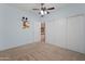 Bright bedroom featuring neutral carpet, ceiling fan, and ample closet space with sliding doors at 19412 N 77Th Ave, Glendale, AZ 85308