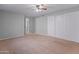 Spacious bedroom with plush carpeting, ceiling fan, closet, and an open doorway at 19412 N 77Th Ave, Glendale, AZ 85308