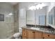 This stylish bathroom features a step-in shower and granite counters on wood cabinets at 19475 N Grayhawk Dr # 1046, Scottsdale, AZ 85255
