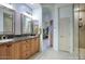 Elegant bathroom with double vanities, granite countertops, and a walk-in glass shower at 19475 N Grayhawk Dr # 1046, Scottsdale, AZ 85255