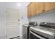 A modern laundry room is equipped with front loading washer and dryer, plus upper cabinets at 19475 N Grayhawk Dr # 1046, Scottsdale, AZ 85255