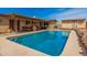 Sparkling backyard pool with a covered patio, brick house, and clear blue sky above at 20053 N 15Th Dr, Phoenix, AZ 85027