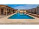 Backyard pool with a covered patio, exterior building, and decorative wood accents around the border at 20053 N 15Th Dr, Phoenix, AZ 85027