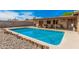 A rectangular backyard pool with surrounding concrete deck, gravel area, and wood accents at 20053 N 15Th Dr, Phoenix, AZ 85027