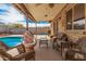 Covered patio with brick columns, ceiling fan, and wicker furniture overlooking a pool and block fence at 20053 N 15Th Dr, Phoenix, AZ 85027