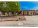Charming brick home featuring a large tree, covered parking, and desert landscaping at 20053 N 15Th Dr, Phoenix, AZ 85027