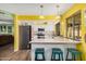 Open kitchen with breakfast bar, stainless steel appliances, and wood floors at 20053 N 15Th Dr, Phoenix, AZ 85027