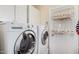 Bright laundry room features a side-by-side washer and dryer and white cabinets above at 20053 N 15Th Dr, Phoenix, AZ 85027