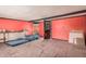 An unfinished room with red walls, damaged tile floor, and a wooden exterior door at 20053 N 15Th Dr, Phoenix, AZ 85027