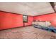 Unfinished room with red walls, damaged floor, and a window with a view to the outside at 20053 N 15Th Dr, Phoenix, AZ 85027