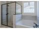 Modern bathroom featuring a glass-enclosed shower and a luxurious soaking tub at 20258 W Catalina Dr, Buckeye, AZ 85396