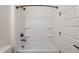 Bathroom with a standard white shower-tub combo with black fixtures and white door at 20258 W Catalina Dr, Buckeye, AZ 85396