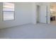 Bright bedroom featuring neutral paint, carpet, baseboards, a window, and an ensuite bathroom at 20258 W Catalina Dr, Buckeye, AZ 85396