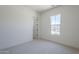 Comfortable bedroom with neutral carpet, white trim, and a view from the window at 20258 W Catalina Dr, Buckeye, AZ 85396