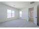 Bright bedroom featuring neutral paint, carpet, baseboards, and multiple large windows at 20258 W Catalina Dr, Buckeye, AZ 85396