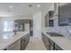 Modern kitchen with dark cabinets, center island, stainless appliances and mosaic backsplash at 20258 W Catalina Dr, Buckeye, AZ 85396