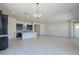 Bright open concept living room and kitchen area with tiled floors and a chandelier at 20258 W Catalina Dr, Buckeye, AZ 85396