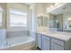 A bathroom features a tub, a large window, dual sinks, and a spacious gray-tiled shower at 20263 W Catalina Dr, Buckeye, AZ 85396