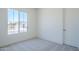 Well-lit bedroom with a large window, neutral walls, and carpet, providing a serene retreat at 20263 W Catalina Dr, Buckeye, AZ 85396
