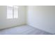 A bedroom with neutral carpet and a bright window at 20263 W Catalina Dr, Buckeye, AZ 85396