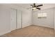 Bedroom with neutral carpet, a ceiling fan, and a closet with sliding doors for ample storage at 299 N Comanche Dr, Chandler, AZ 85224