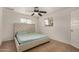 Bright bedroom featuring carpet, a ceiling fan, and two windows for natural light at 299 N Comanche Dr, Chandler, AZ 85224