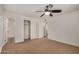 Open bedroom layout showing neutral carpet, a ceiling fan, and access to the bathroom and closet at 299 N Comanche Dr, Chandler, AZ 85224