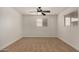 Spacious bedroom with a ceiling fan, neutral carpeting, and two windows bringing in natural light at 299 N Comanche Dr, Chandler, AZ 85224