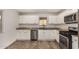 Bright kitchen featuring white cabinets, stainless steel appliances, and wood-look flooring at 299 N Comanche Dr, Chandler, AZ 85224