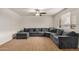 Inviting living room with a sectional couch, ceiling fan, plush carpeting, and natural light at 299 N Comanche Dr, Chandler, AZ 85224