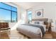 Bright bedroom with large windows offering city views, with cozy chair and neutral decor at 3131 N Central Ave # 7002, Phoenix, AZ 85012