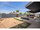 A view of the backyard that features a brick fence, covered patio, and lush palm trees at 3222 W Marshall Ave, Phoenix, AZ 85017