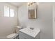 Bright bathroom features a modern vanity, mirror, and toilet under natural light at 3222 W Marshall Ave, Phoenix, AZ 85017