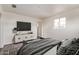 Modern bedroom with a large TV, sleek dresser, and ample natural light from the window at 3222 W Marshall Ave, Phoenix, AZ 85017