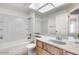 Well-lit bathroom featuring a tub, white tile, vanity with wood cabinets, and stone countertop at 3339 W Mohawk Ln, Phoenix, AZ 85027
