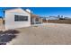Back exterior of the home showcasing a gravel yard, covered patio, and surrounding block fence at 3339 W Mohawk Ln, Phoenix, AZ 85027
